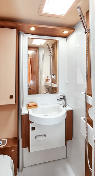 Handfat och vägg kan svängas undan för att skapa ett duschutrymme. Smart!