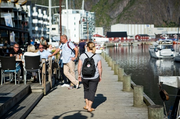 Turisterna njuter av augustisolen längs med kajkanten i Svolvaer.