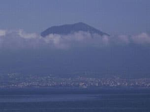 Vesuvius i fjärran. Gömd bakom molnen framstår vulkanen som ett realistiskt hot