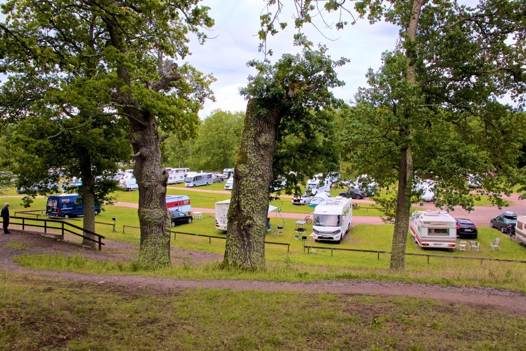 Mariefred strandbad har sandstrand, gräsytor och en brygga i vinkel. 