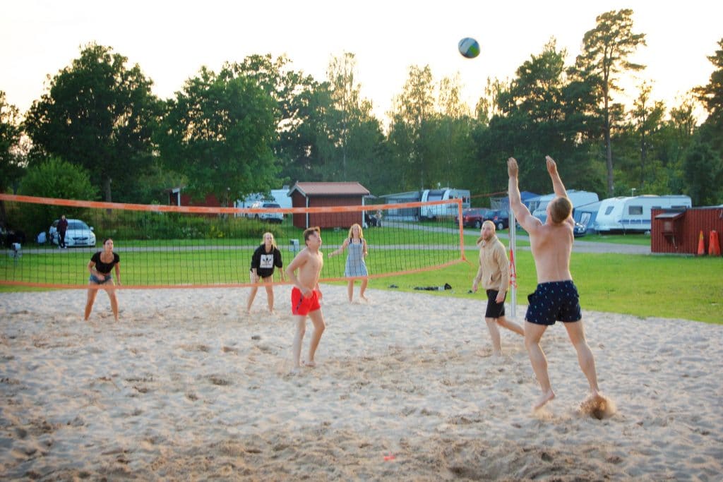 Testa en beachvolleyboll-match med vännerna. 